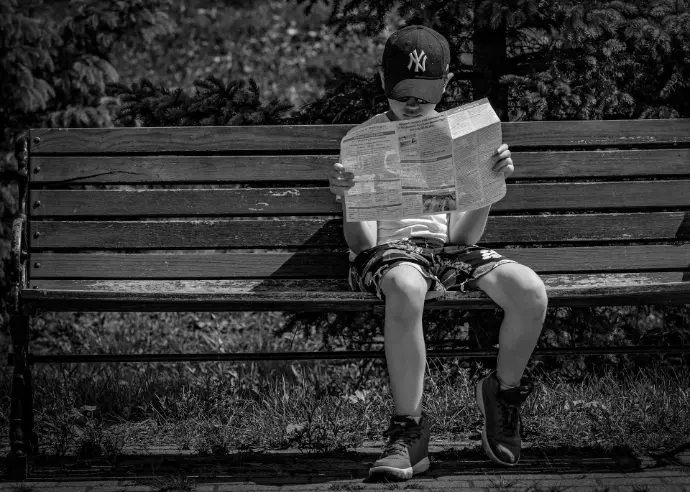 grayscale photo of woman sitting on bench